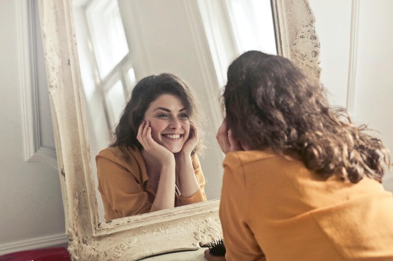 Smiling woman holding an apple representing healthy lifestyle and medically assisted weight loss at Wellness and Hormone Health in Centennial, CO
