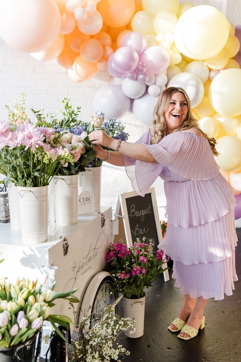 Carissa Corsi laughing while setting up a floral display