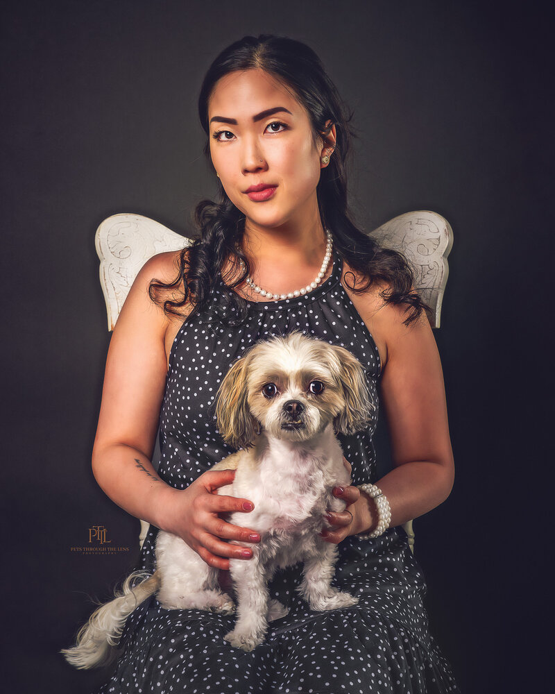 Experience fine art photography with our exquisite portraits featuring people and their pets in Vancouver. This stunning image captures a woman in a vibrant dress sharing a moment with her white dog against a richly detailed Victorian backdrop. Pets Through the Lens creates timeless, artistic portraits that celebrate the special bond between humans and their furry companions.