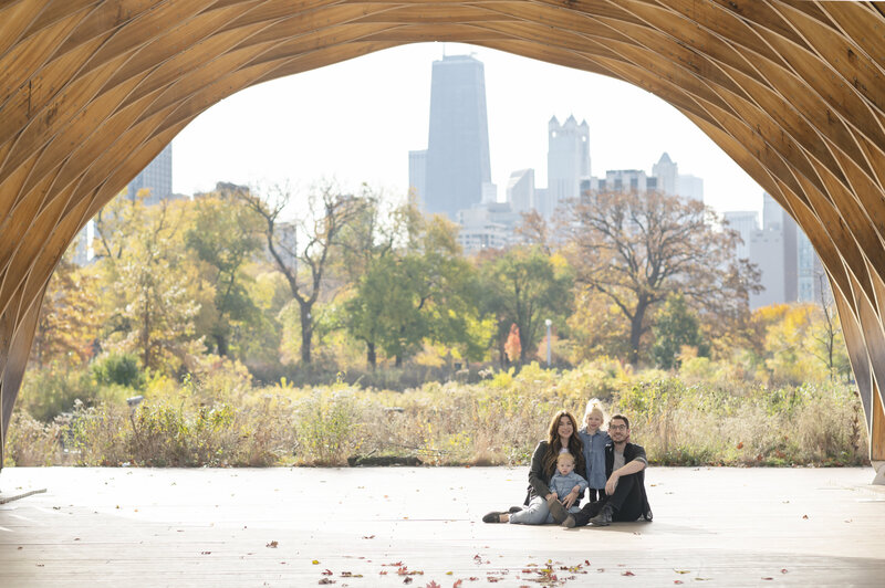 Family posing at Chicago's Lincoln Park Zoo Honeycomb with view of Chicago skyline