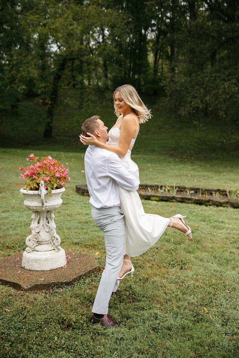 Man spinning woman around in a field during Nashville engagement session