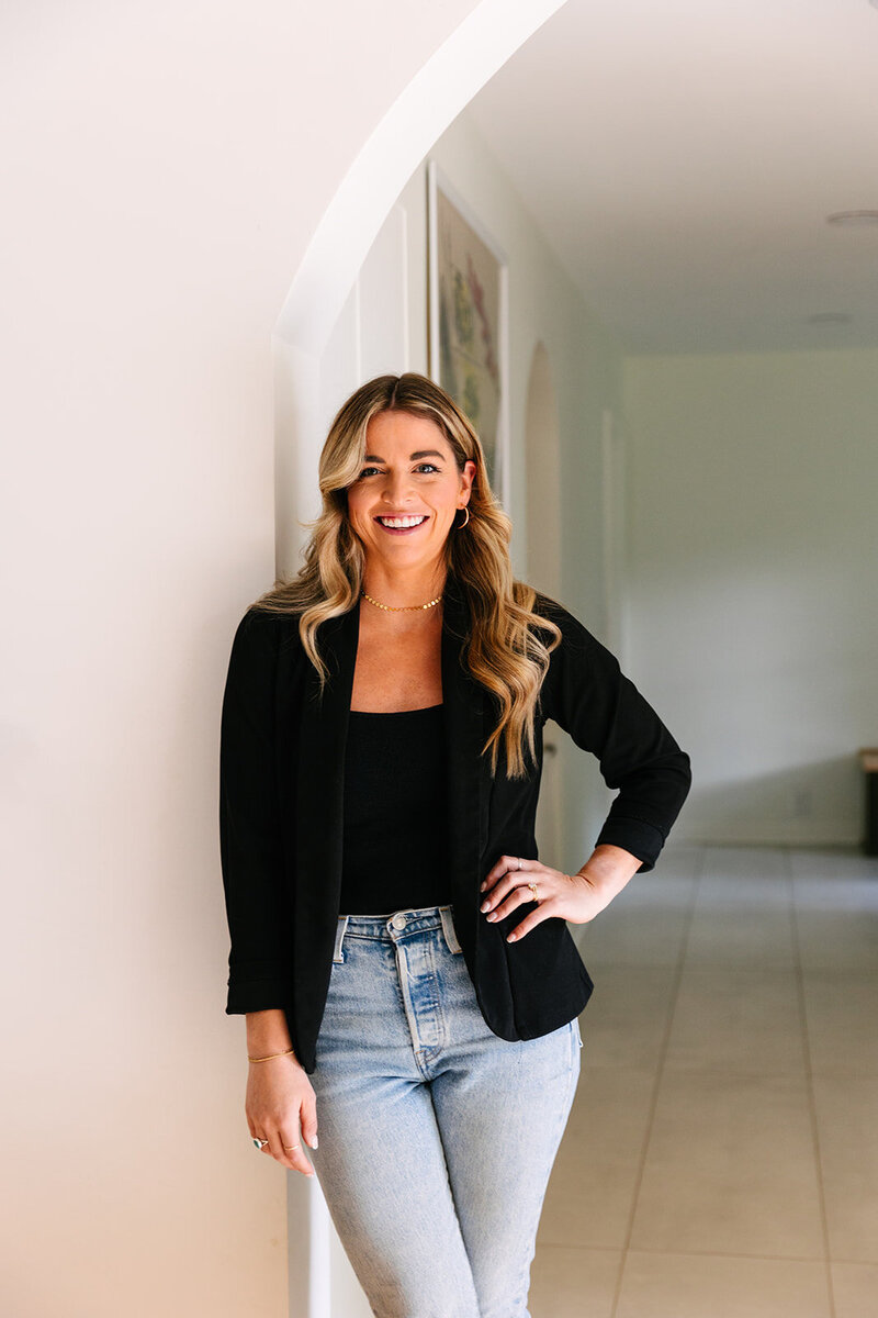 Hannah standing in bright arched hallway - West Village Realty