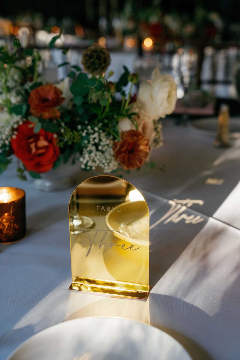 Gold table number at wedding reception.