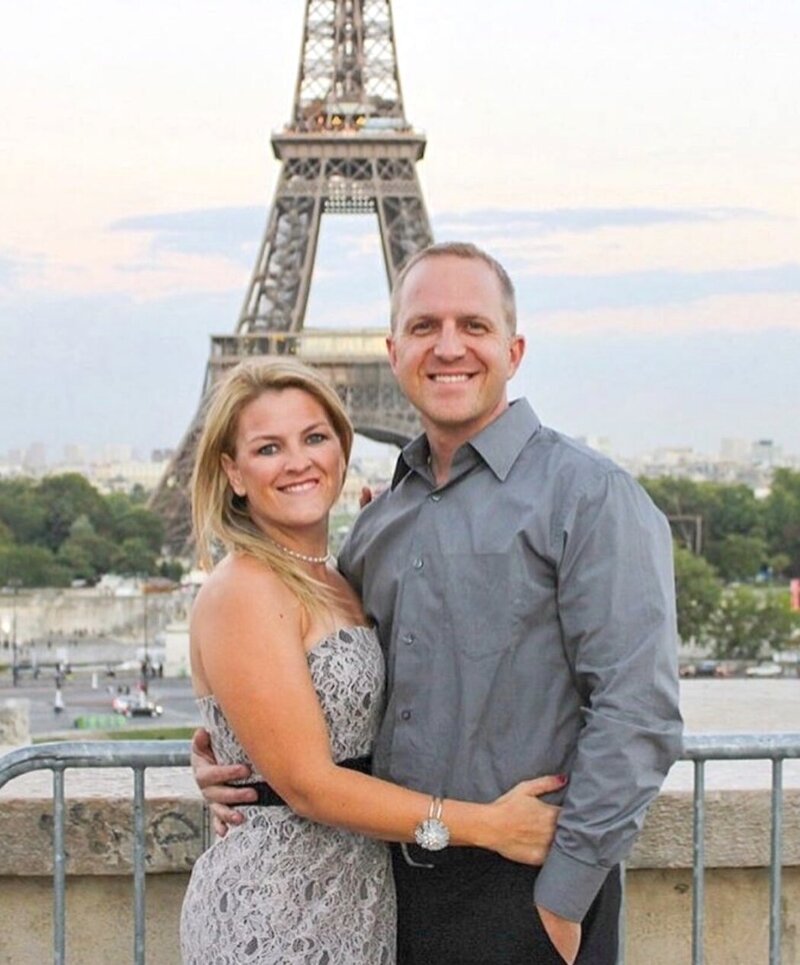 Married wedding photographers on vacation in front of the Eiffel Tower dressed up in pretty dress.