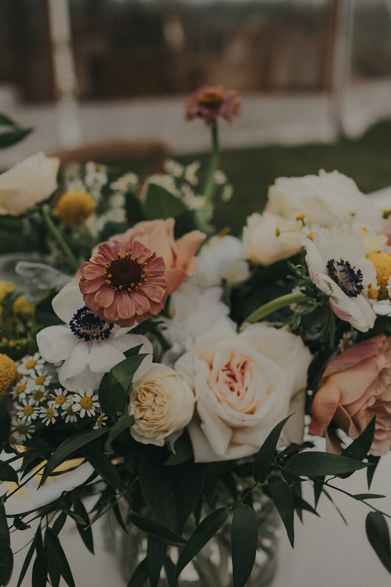 Joli arrangement floral pour un mariage sous chapiteau.