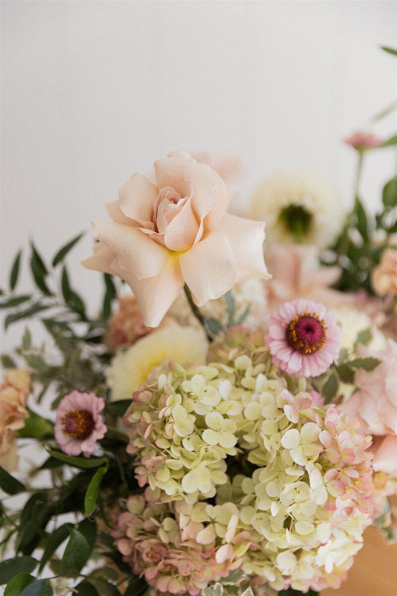 Bride & Groom being showered in confetti at their ceremony with the bride holding her seasonal wedding floral bouquet 