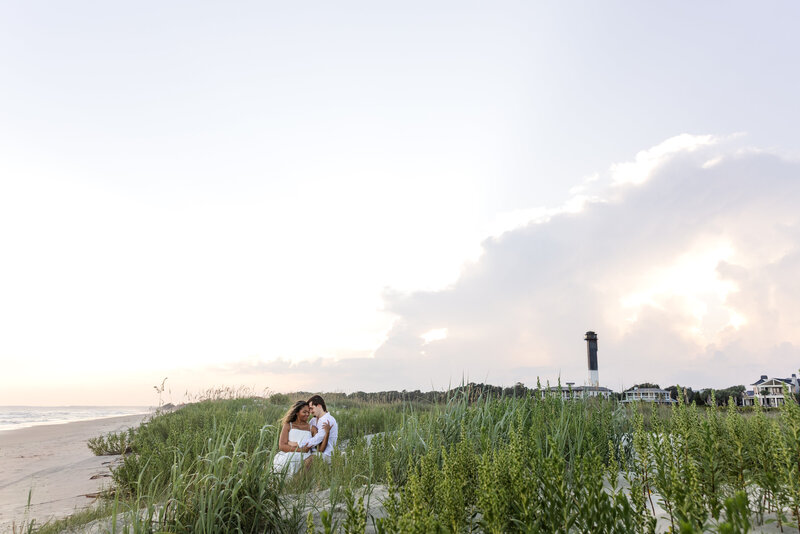 Couple holding hands sitting on the beach together