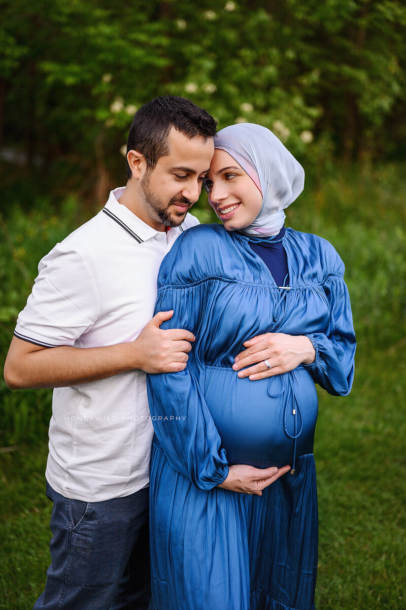 Luxury maternity photography in Grand Rapids, MI—an intimate moment between expecting parents, captured in a fine art outdoor maternity session. Honey Wild Photography specializes in high-end maternity portraits with timeless elegance