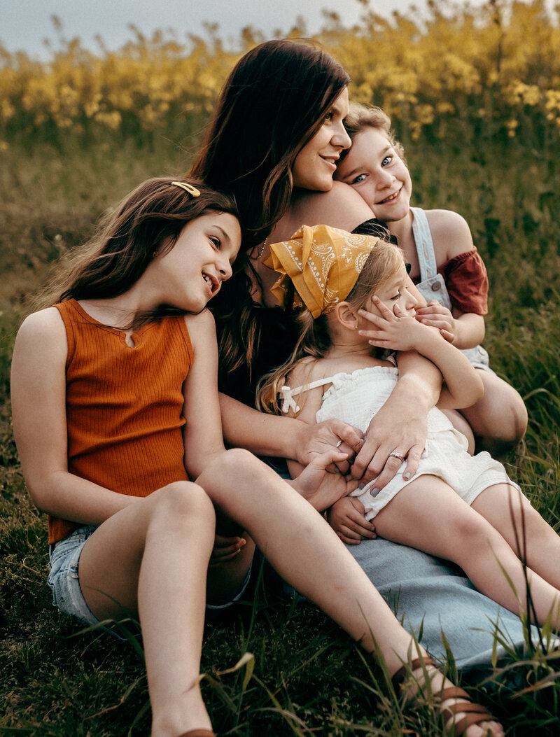 mom sitting in field with girls next to flower field in PA-Family-photographer-lehigh-valley-pennsylvania
