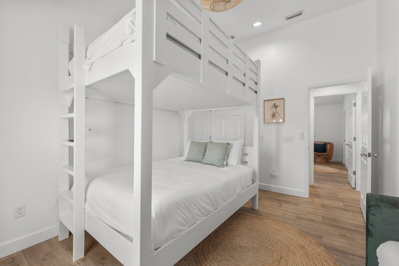 Modern guest room with custom bunk bed and entry to hallway, designed for families or groups booking Santa Rosa Beach or Destin rentals.