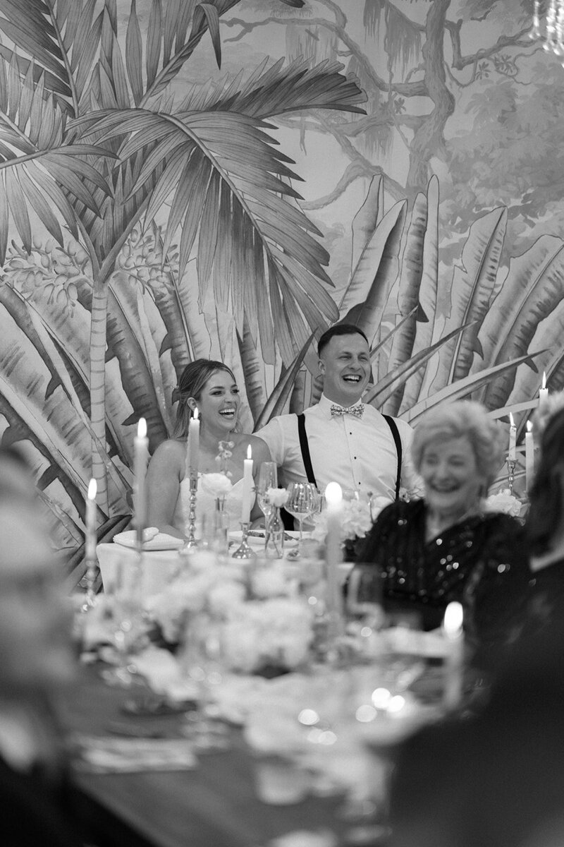 A bride and groom laugh during sentimental speeches at their wedding reception in New Jersey.