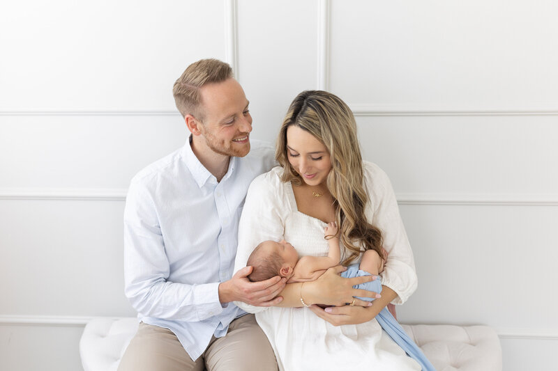 Parents looking at their newborn in studio