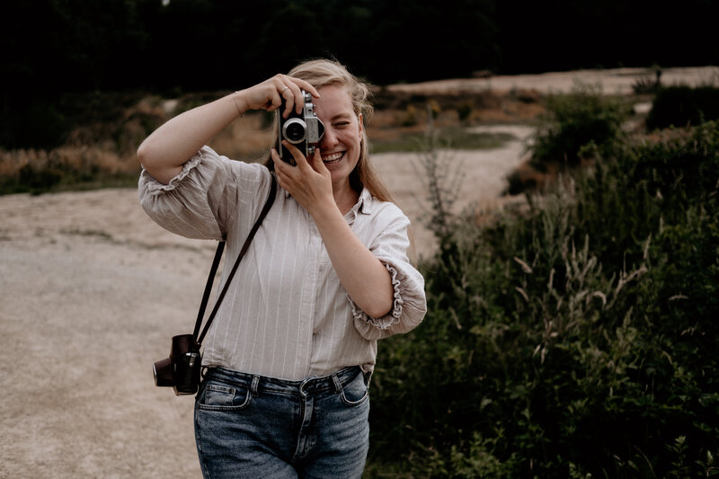 Lachende fotograaf met oude camera