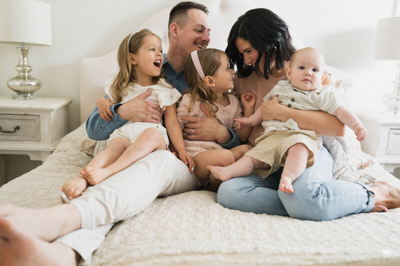 family laughing together on bed