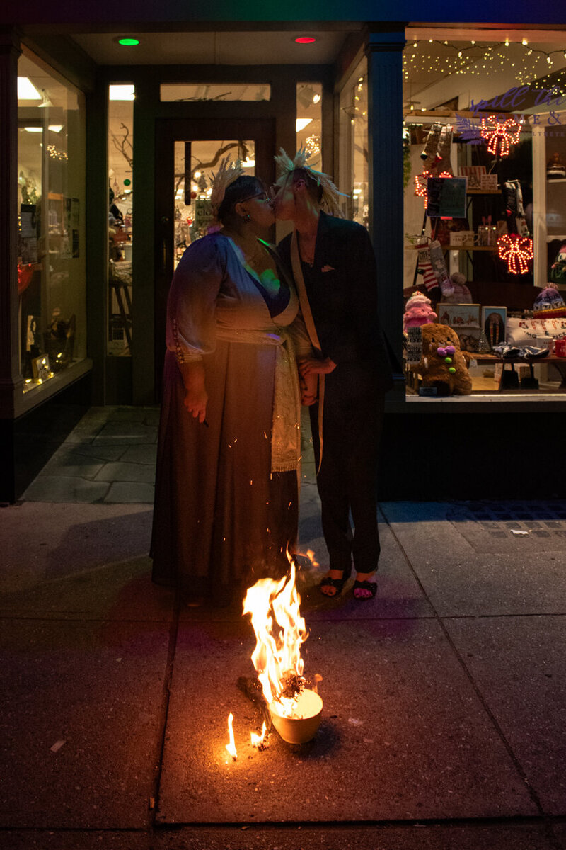 A couple kissing in front of a fire in Northampton, Massachusetts. It was a queer couple's micro wedding and it was intentional, cinematic, thoughtful and unique. 