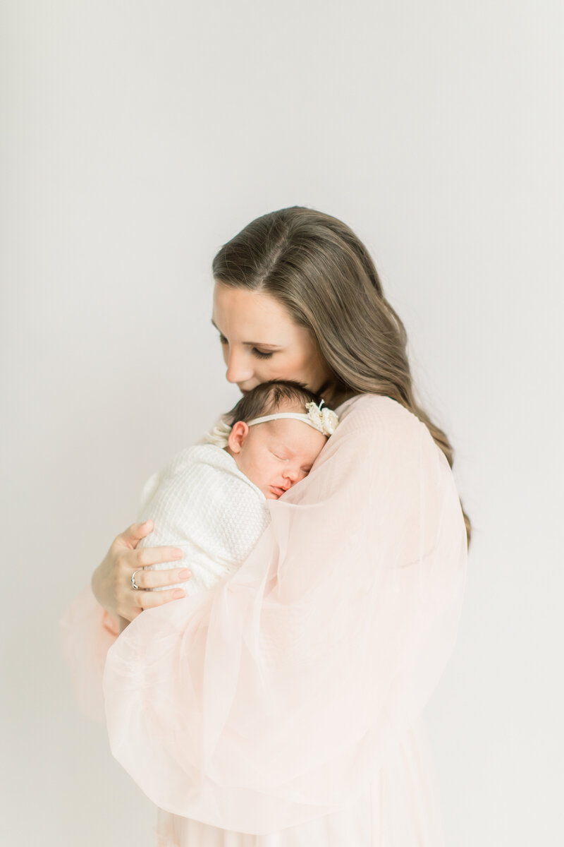 Mother holding newborn baby swaddled