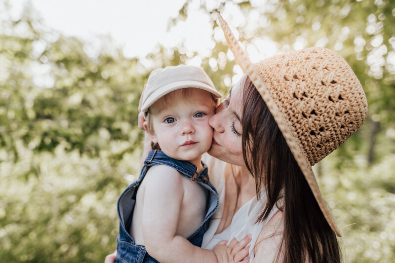 Family photography session or a mother kissing baby boy on the cheek