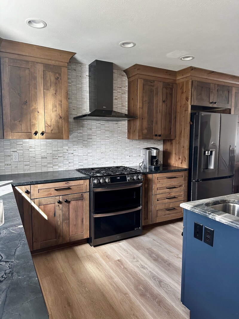 Kitchen with marble countertops, dramatic light fixtures and a deep blue island
