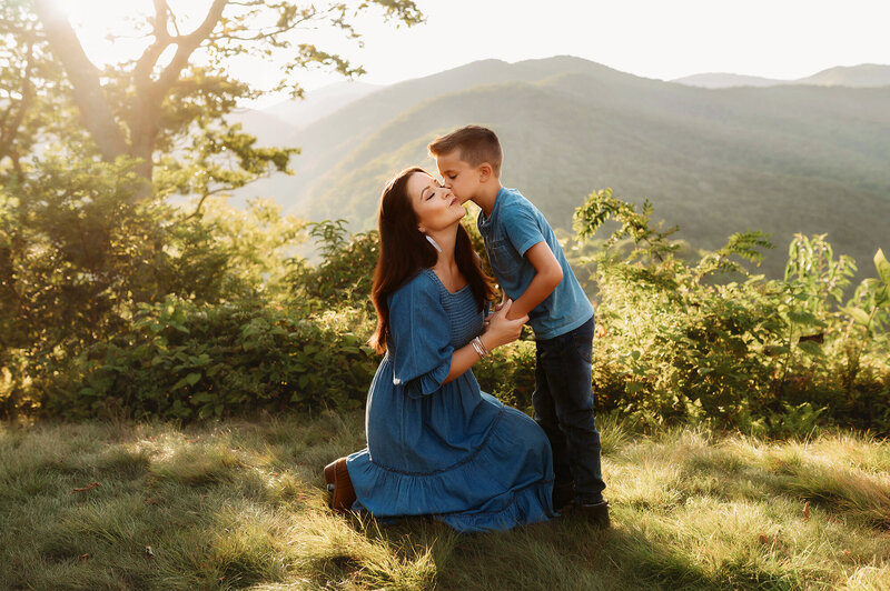 Mother kisses her son durnig family photo session in Asheville, NC.