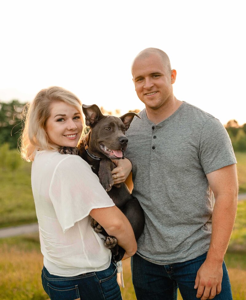couple holding their dog in engagement photo