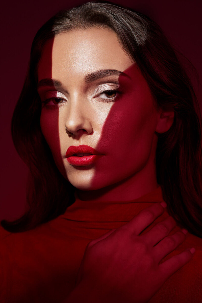 Elegant portrait of Luciana Cid in a red outfit and veil, with bold red lipstick, captured by Ylva Erevall.