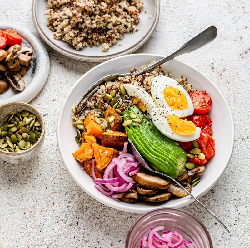 Rainbow Menopause Abundance Bowl topped with avocado, eggs, roasted veg, and seeds — a nourishing, hormone-supportive meal for midlife women.