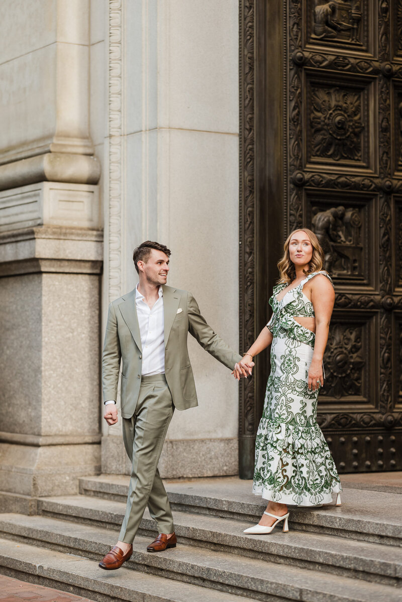 Bride and groom romantically standing by the gates of the Philadelphia City Hall with the veil flowing in the background.