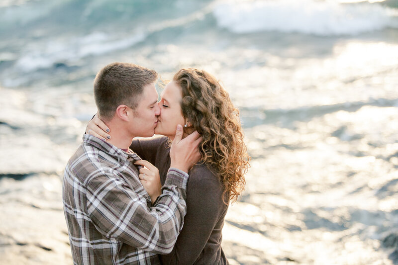 couple cuddles on top of lake superior bluff minnesota engagement