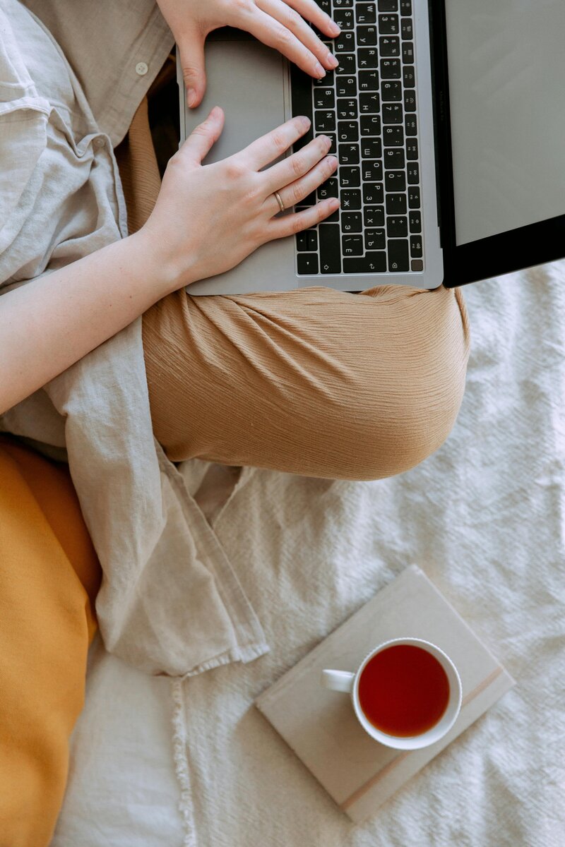 A cozy home office setup featuring a computer and tea, representing the flexibility and comfort of working from home as a virtual assistant. Creative Dynamics offers expert virtual assistant services across the USA and Canada, providing efficient support and management to enhance your business operations.