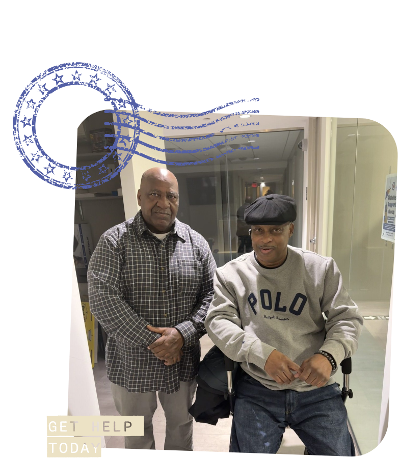 two men, one being in a wheel chair, in a hallway