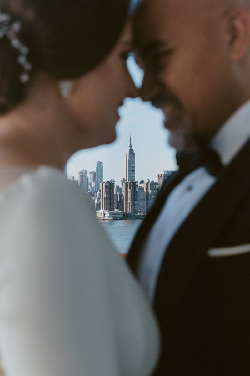 Bride and groom blurry with city skyline in focus in background