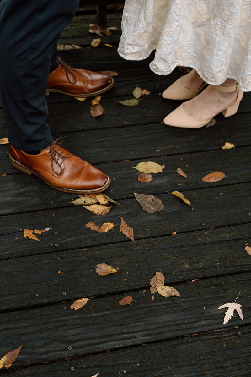 couples shoes standing in the leaves at shelby bottoms park in nashville