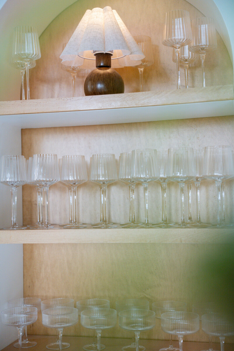 Champagne glasses and vintage lamp on bar neutral shelving installation