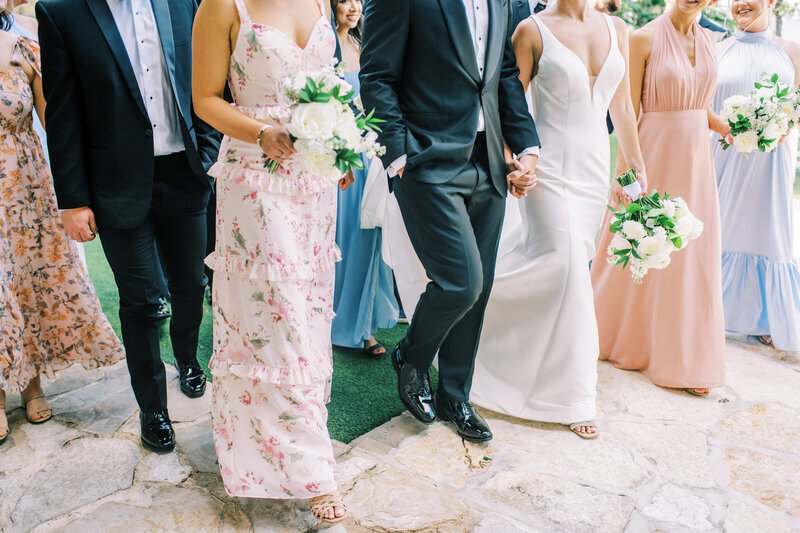 Close up image of a bride and groom and their wedding party all walking together