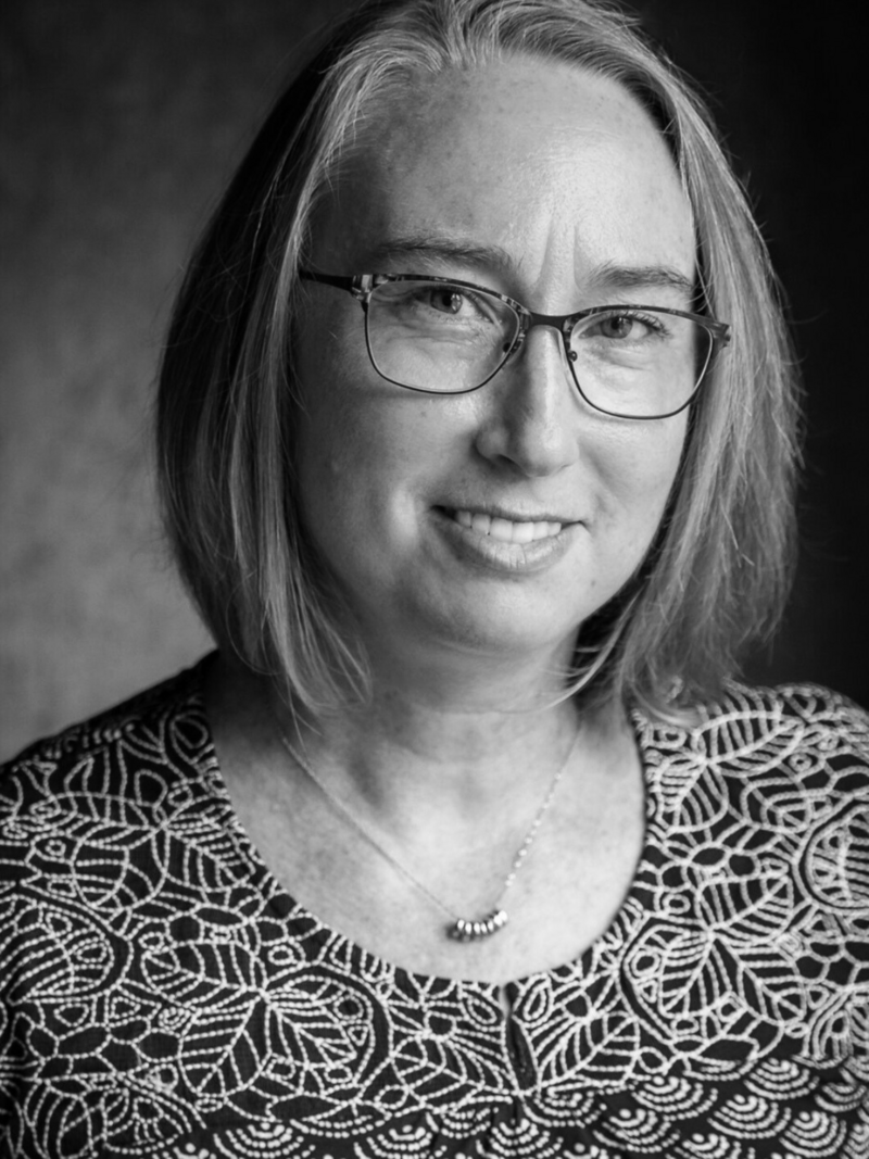 jenny adams woman with short blond hair and glasses smiling at camera headshot