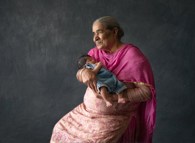  grandmother holding her grandson dressed in pink sari