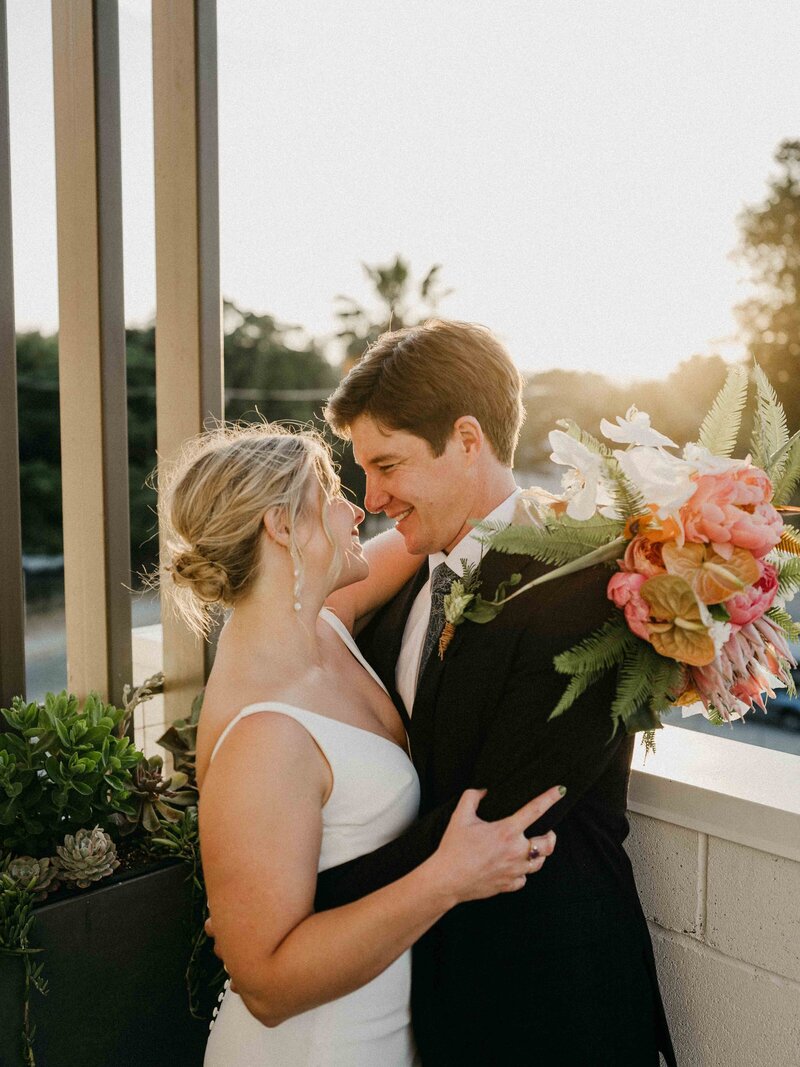 a newly wed couple embraces atop Hart and Main's Garden Terrace at Sunset 