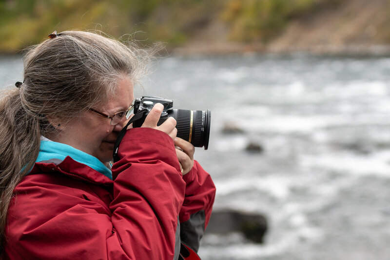 Image of Amy Hodder capturing a photo of the scenic Yellowstone River