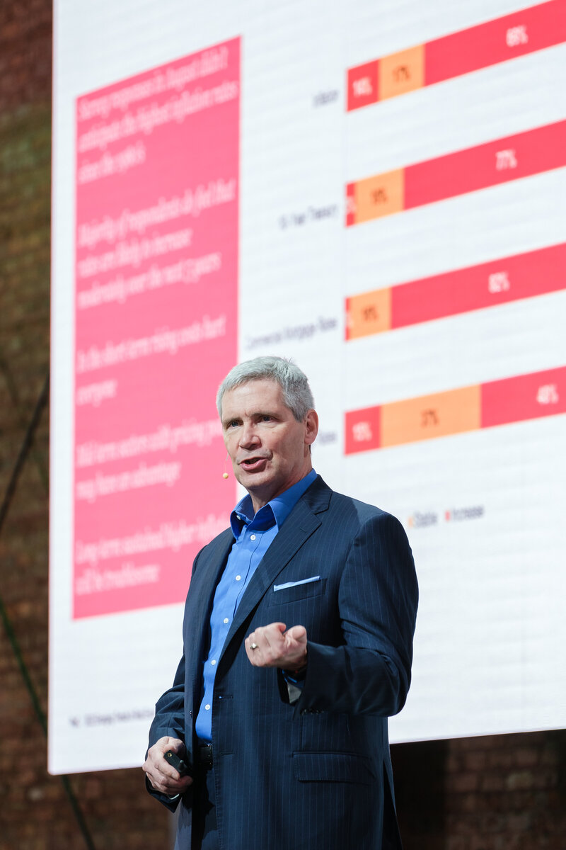 Speaker stands on stage in front of a chart during a presentation at Armature Works in Tampa Florida