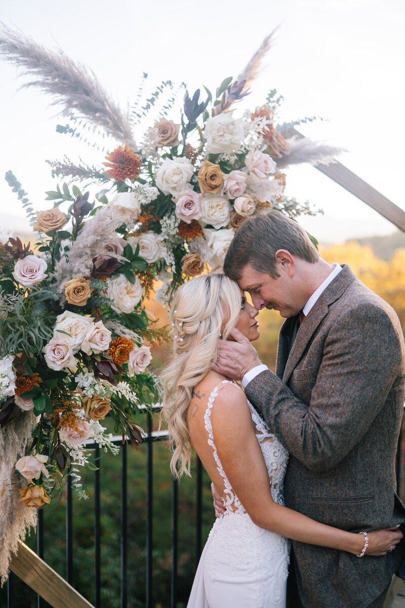 Lake Tahoe wedding photographer captures bride and groom embracing under boho wedding alter