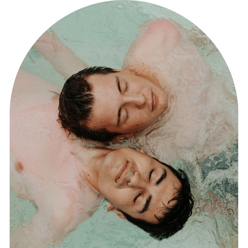 Couple floating in the water with their eyes closed