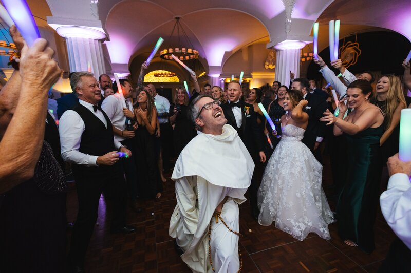 modern priest dancing on the dance floor at a wedding