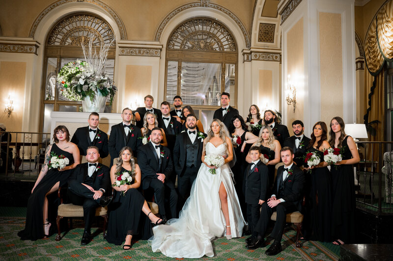 bridal party posing for fun photo inside omni william penn hotel lobby
