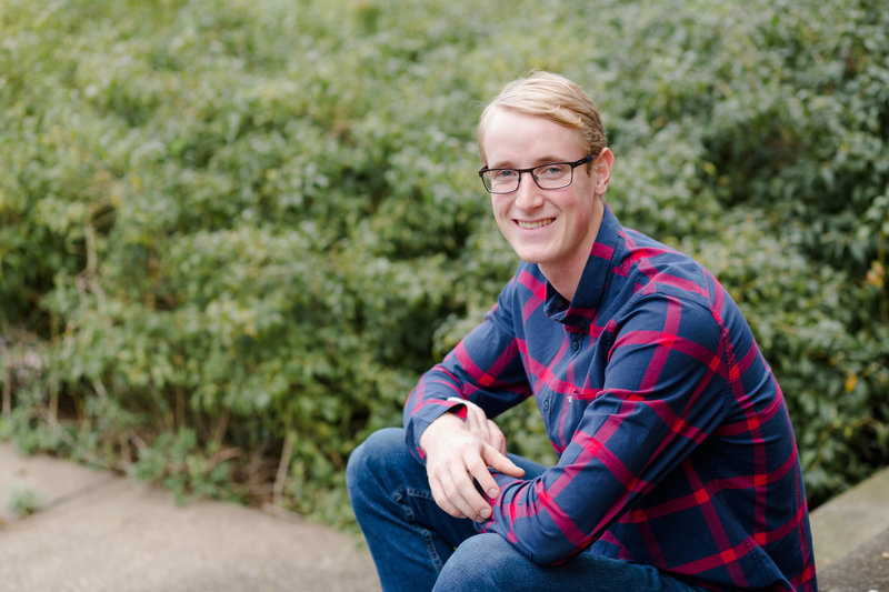 triway high school senior guy sitting on stepes, wearing burgundy and navy plaid shirt, photographed at the OARDC in Wooster, photographed by Jamie Lynette photography canton ohio senior photographer