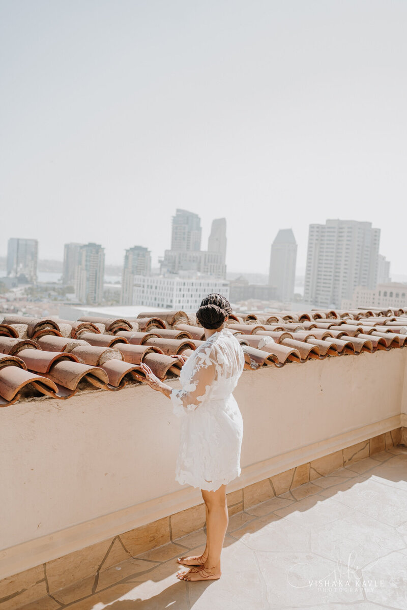 bride standing on a rooftop overlooking a large city