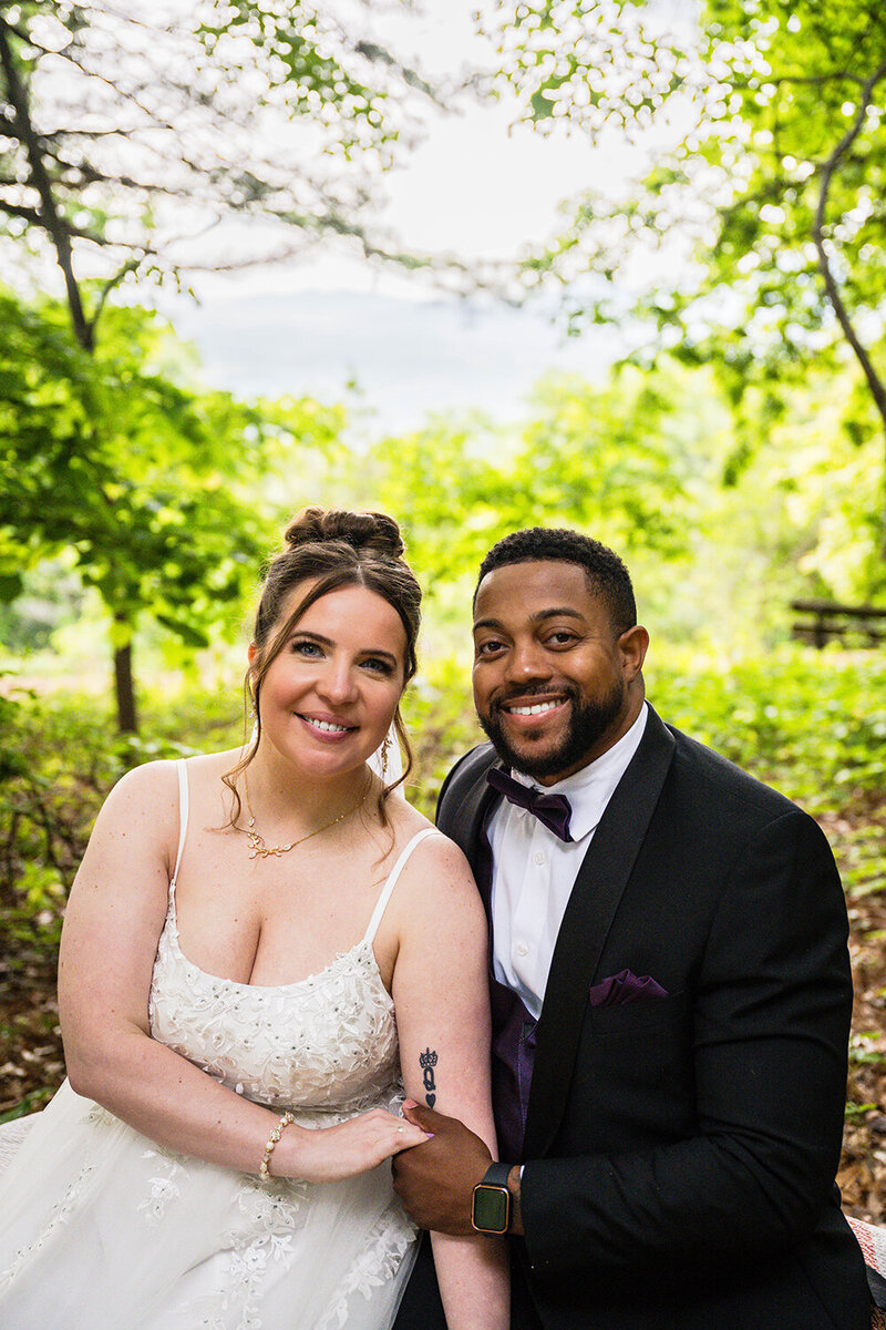 A wedding couple sit on a bench at the Mill Mountain Wildflower Garden on their elopement day in Roanoke, Virginia.