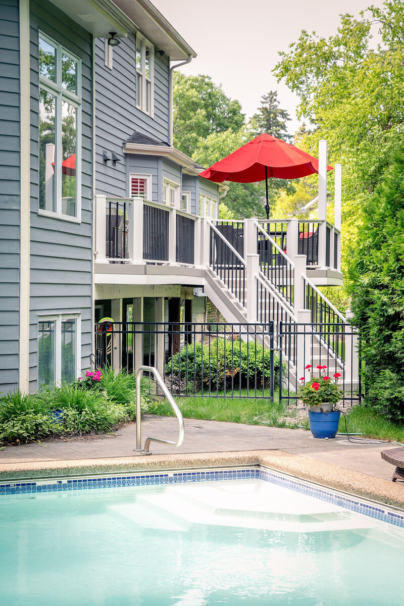 Low-maintenance deck in the background and in-ground swimming pool in the foreground. 