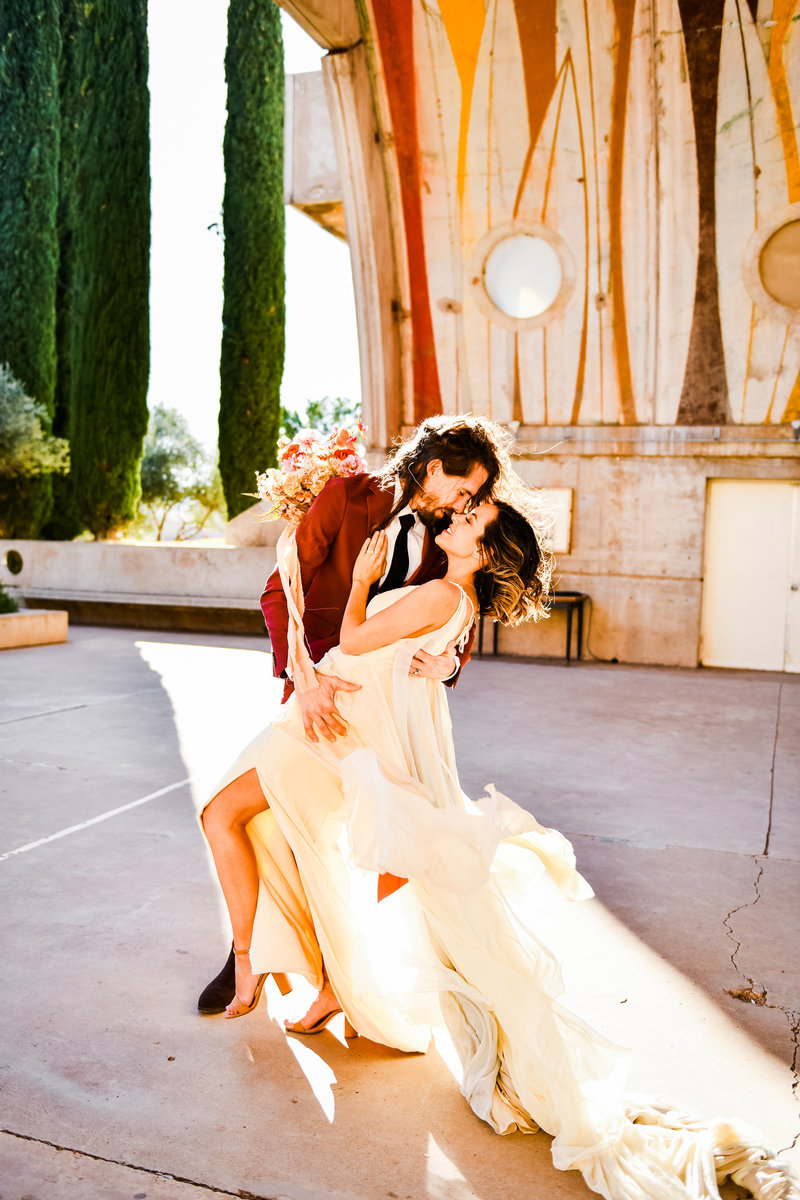 Arcosanti wedding bride and groom couple holding each other colorful