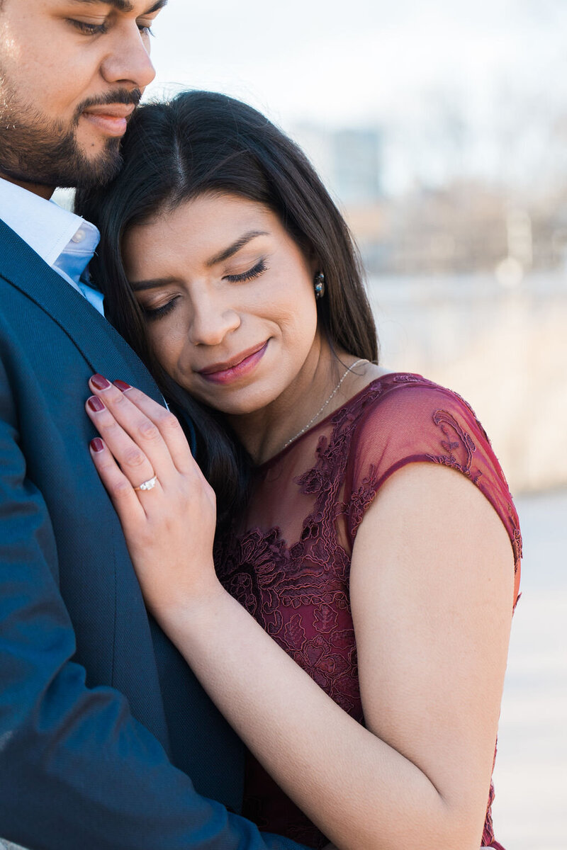 engaged bride resting on groom's chest