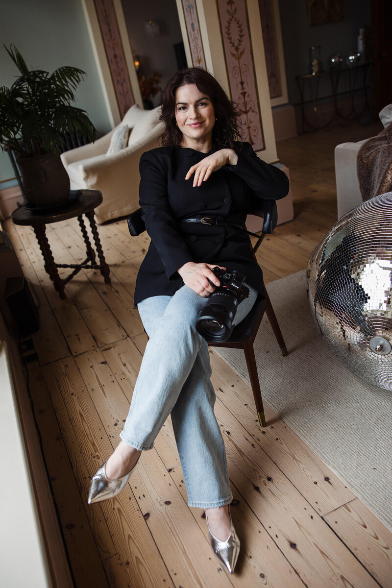 Laura May, UK wedding photographer, smiling in natural light, capturing timeless, vibrant, and artistic wedding photography for sentimental couples across the UK.